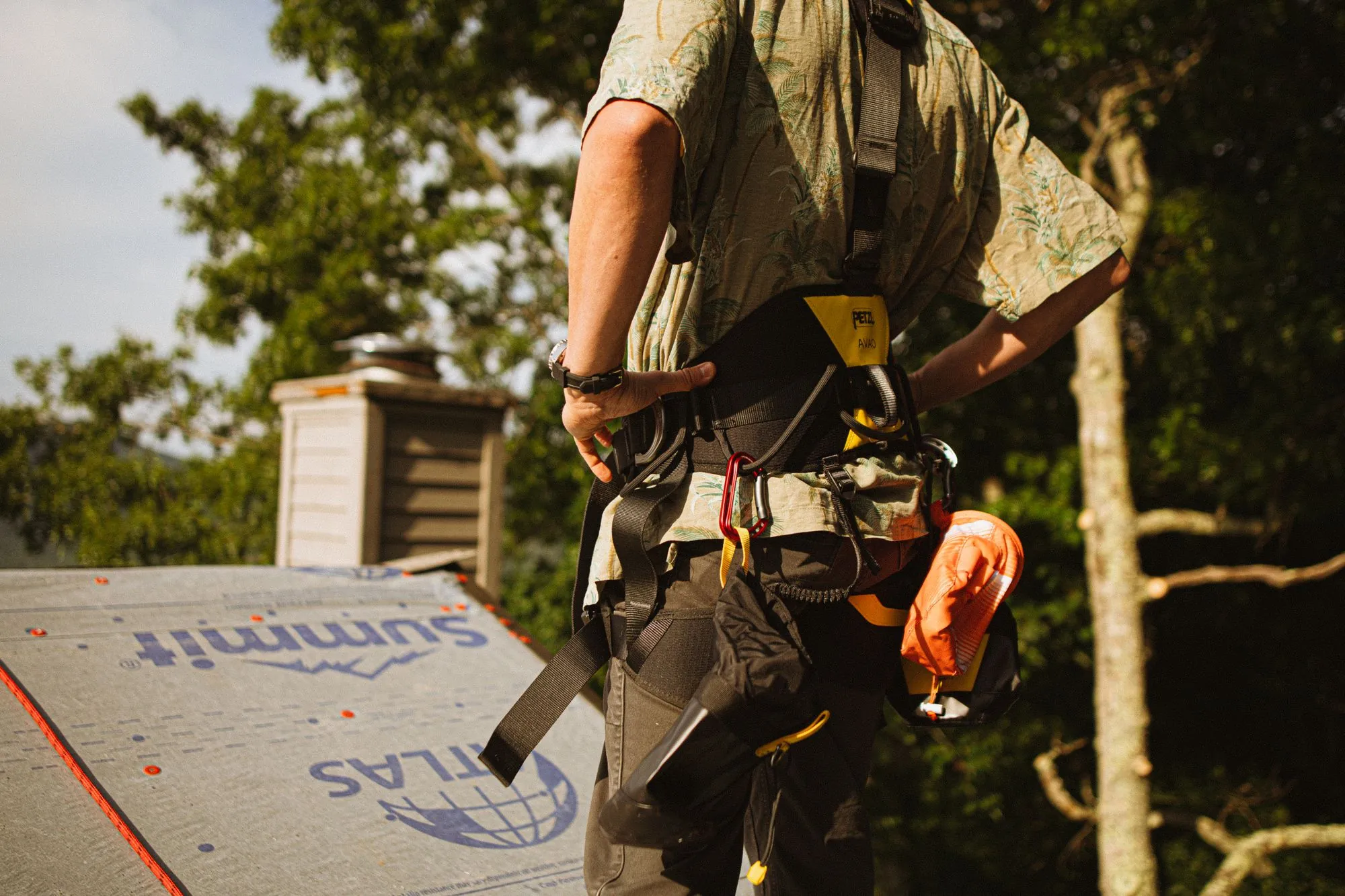 Roofing crew carrying bundles and underlayment across a stripped roof deck
